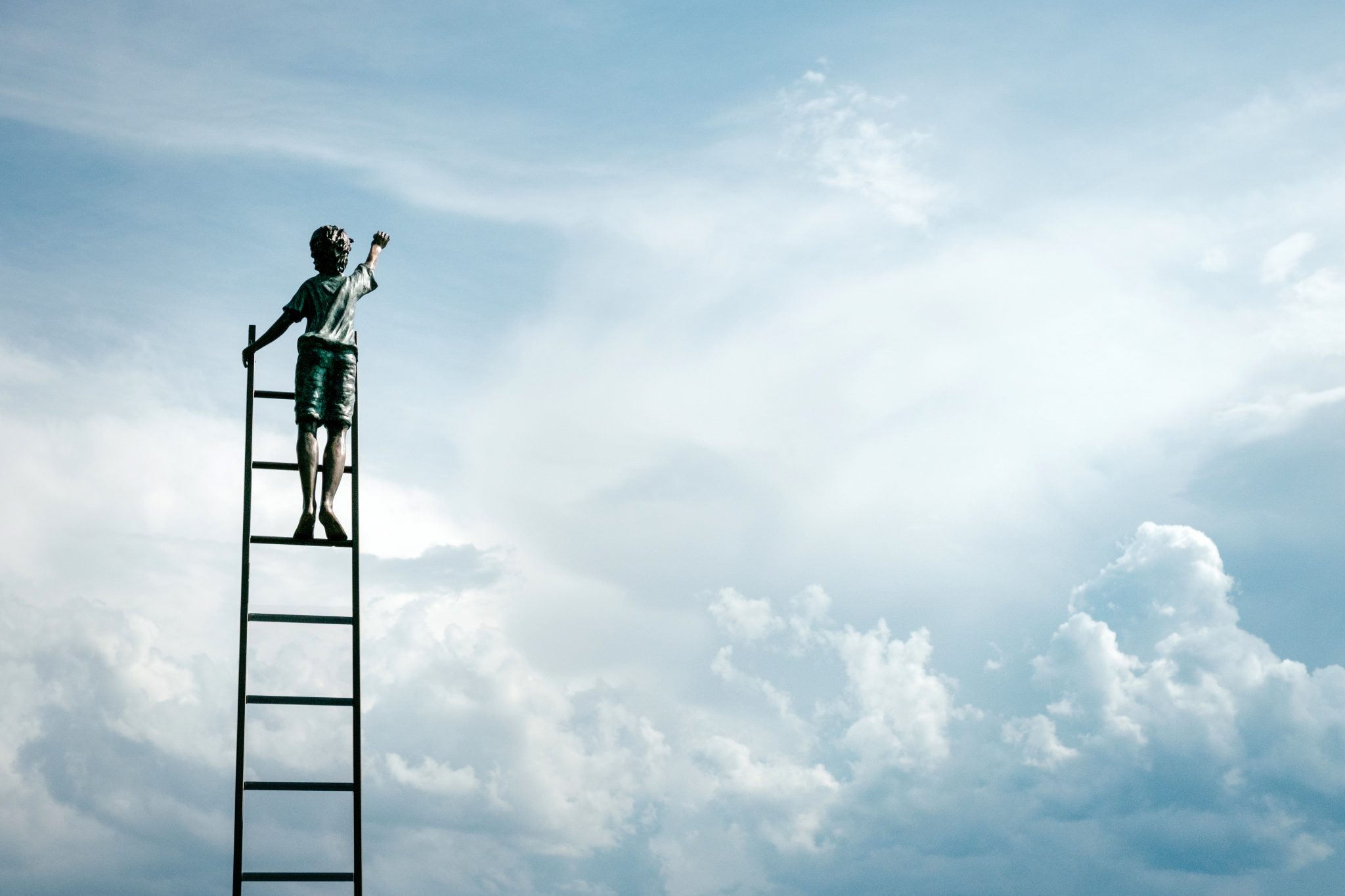 Man climbing a ladder into the clouds